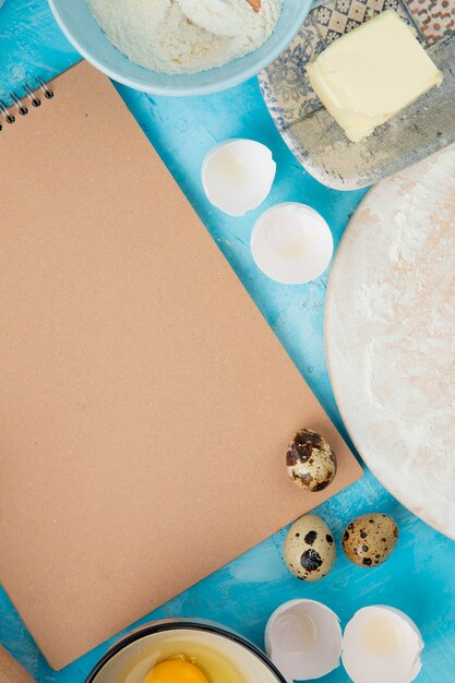 Top view of foods as egg and butter with eggshell on blue background with copy space