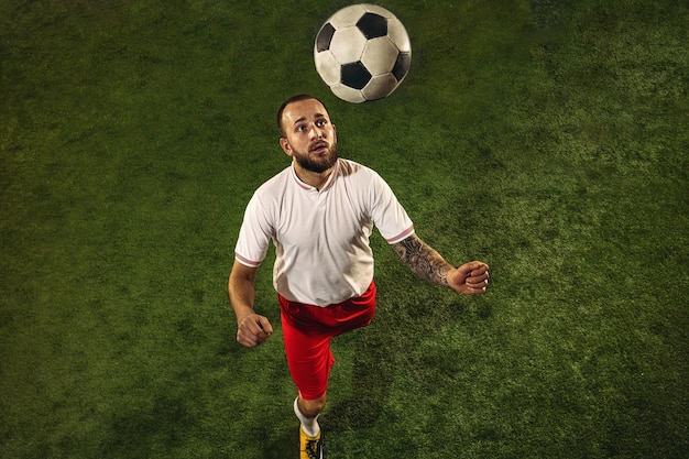 Top view of football or soccer player on green grass