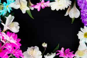 Free photo top view of a frame made of white color alstroemeria flowers with pink and white color chrysanthemum flowers on black background with copy space