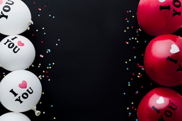 Free photo top view frame with balloons and black background