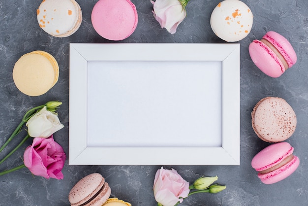 Top view of frame with delicious macarons and roses