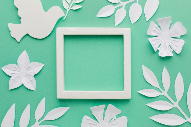 Free photo top view of frame with paper dove and leaves