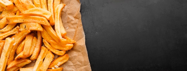 Top view of french fries on paper with copy space