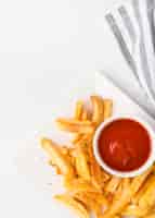 Free photo top view of french fries on plate with ketchup and copy space