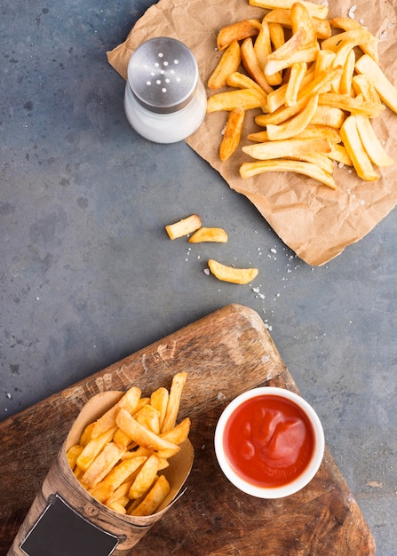 Free Photo top view of french fries with ketchup and salt shaker