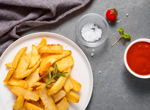 Free Photo top view of french fries with salt on plate and ketchup