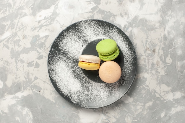 Free photo top view french macarons inside plate on white surface cake sugar bake biscuit sweet tea cookie