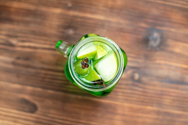 Top view fresh apple juice inside can on a brown wooden desk