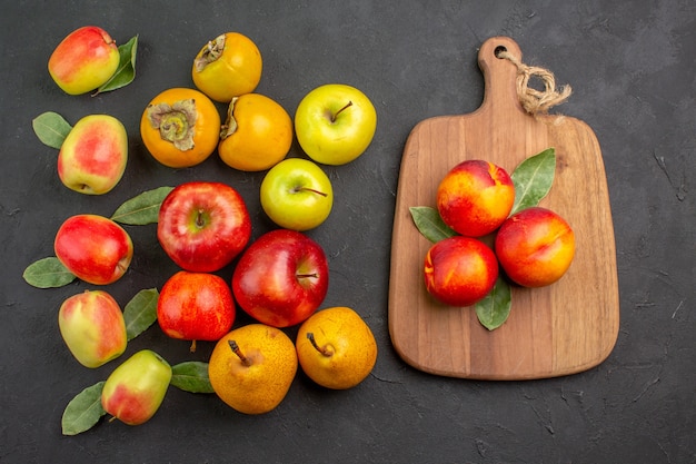 Top view fresh apples with persimmons and pears on dark desk mellow tree fresh ripe