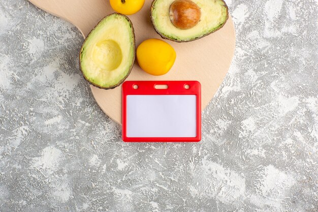 Top view fresh avocados useful fruits on white surface