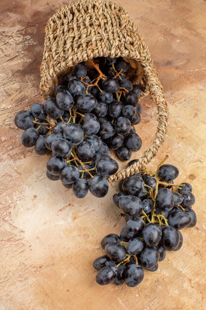 Top view fresh black grapes inside basket on light background