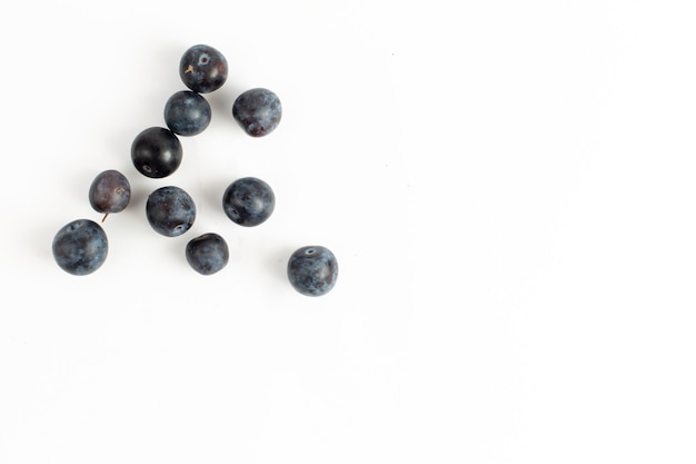 Top view fresh blackthorns sour and dark fruits on the desk background