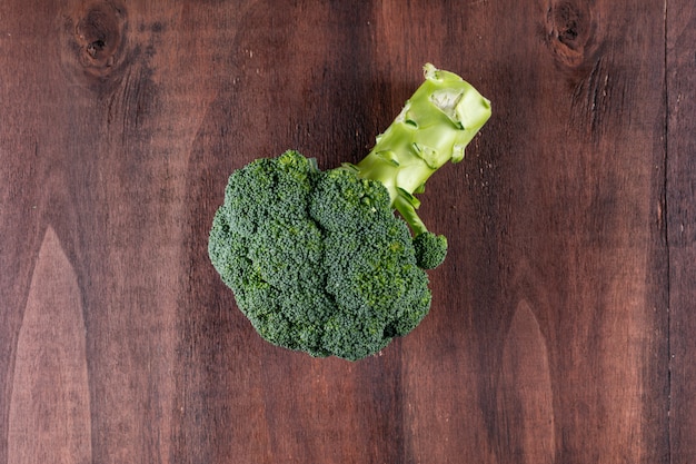 Free photo top view fresh broccoli on brown wooden surface healthy vegetable