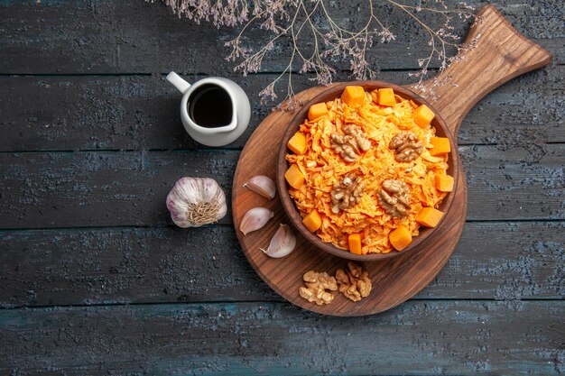 Top view fresh carrot salad with garlic and walnuts on dark-blue desk nut diet health salad vegetable color