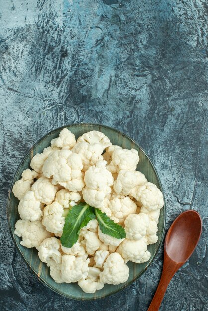 Top view fresh cauliflower inside plate on a light-grey table