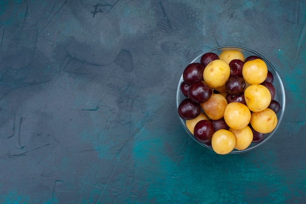 Free photo top view fresh cherries mellow fruits inside glass on the dark-blue background fresh cherry sweet cherry ripe vitamine