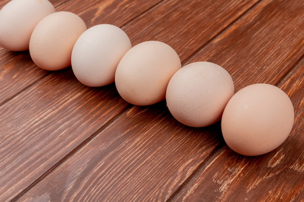 Top view of fresh chicken eggs arranged line on a wooden background