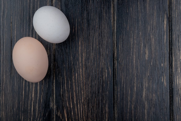 Top view of fresh chicken eggs on a wooden background with copy space