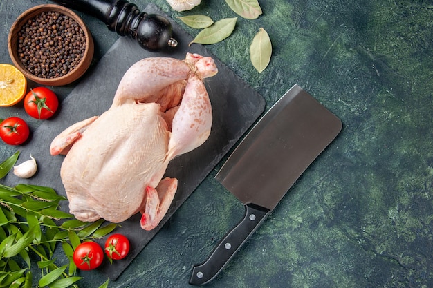 Free photo top view fresh chicken with tomatoes and pepper on dark-blue surface