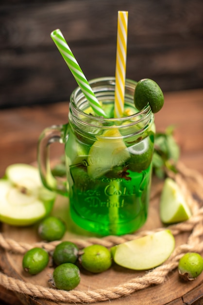 Top view of fresh delicious fruit juice served with apple and feijoas on a wooden cutting board