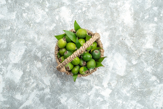 Free photo top view fresh feijoas in wicker basket on grey isolated surface free space