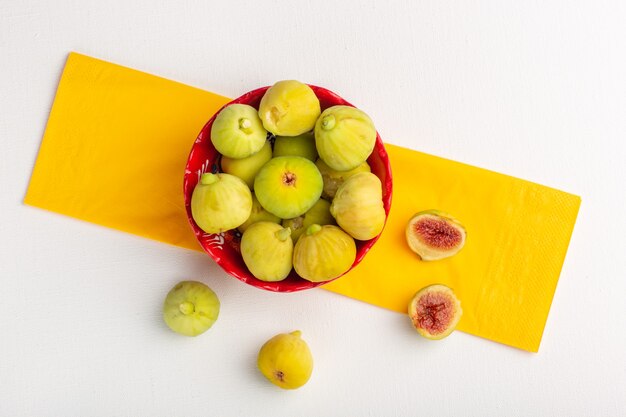 Top view fresh figs sweet and delicious fetuses inside red plate on the white surface