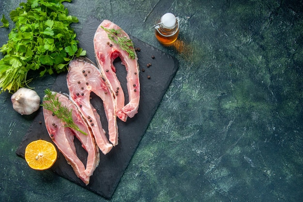 top view fresh fish slices with greens on dark background