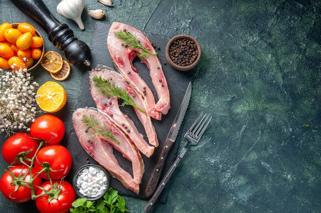 top view fresh fish slices with red tomatoes on dark background