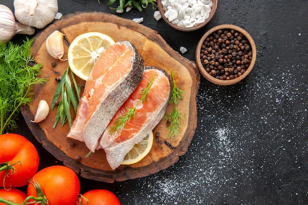 Free Photo top view fresh fish slices with tomatoes and lemon slices on dark table