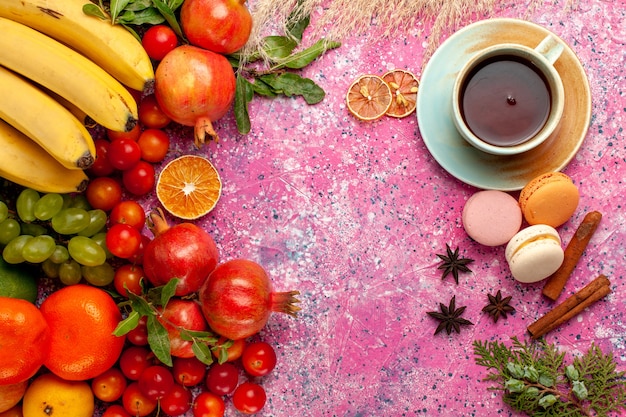 Top view fresh fruit composition with cup of tea on light pink surface