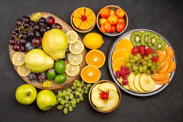 Top view fresh fruits composition sliced and ripe on a dark surface fruit ripe fresh mellow health