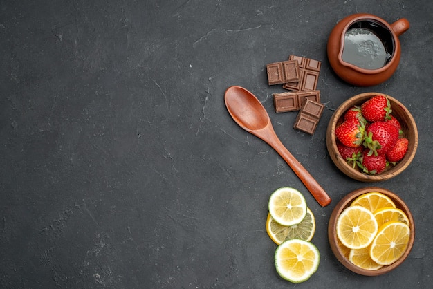 Free photo top view fresh fruits strawberries and lemons on gray surface