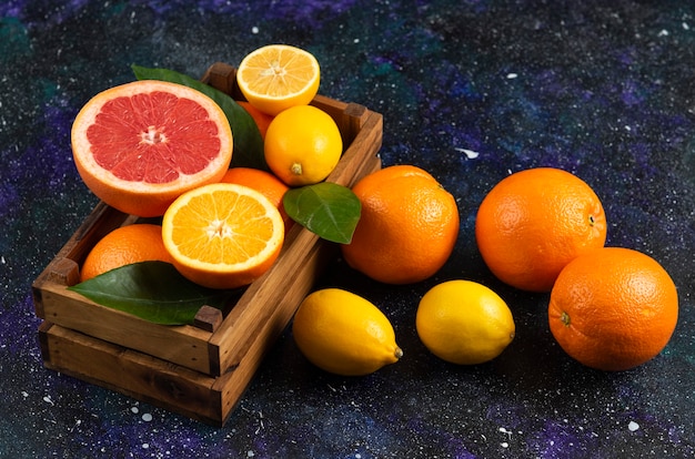 Top view of fresh fruits in wooden basket and ground.