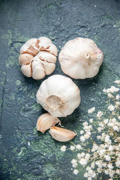 Top view fresh garlics lined on a dark surface greens plant vegetable sour seasoning food pepper