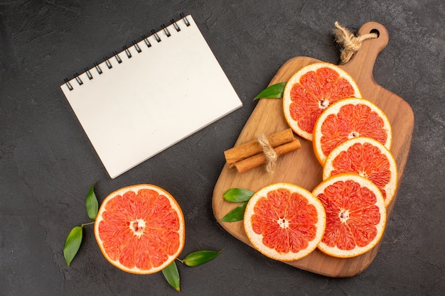 Free photo top view fresh grapefruit slices on dark background