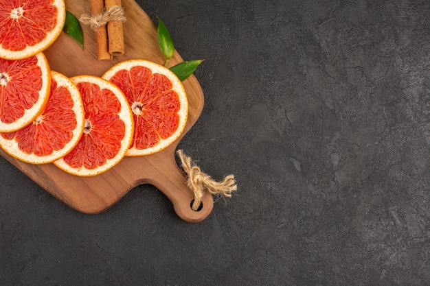 Free photo top view fresh grapefruit slices lined on dark background