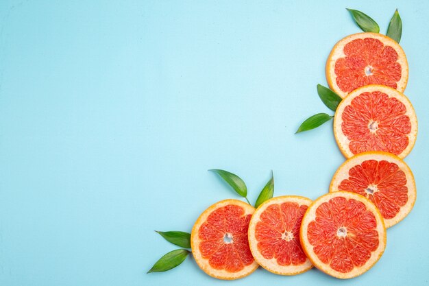 Top view fresh grapefruits fruit slices on blue background