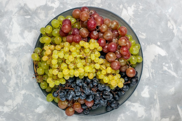 Top view fresh grapes juicy and mellow fruits inside plate on white surface fruit mellow juice wine fresh