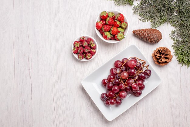 Top view of fresh grapes with berries on wooden table