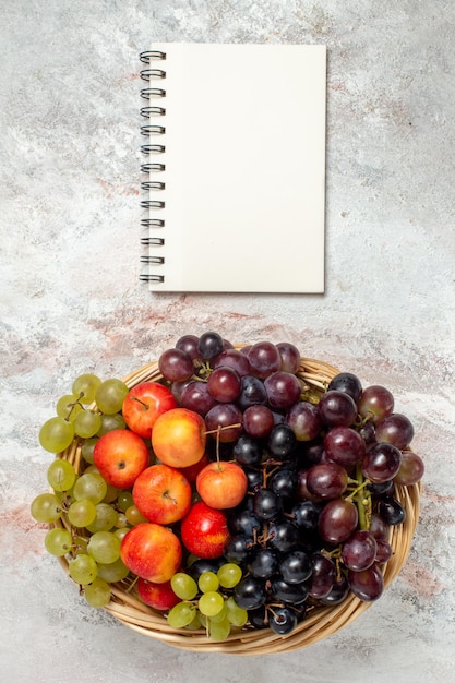 Free photo top view of fresh grapes with plums on a white surface