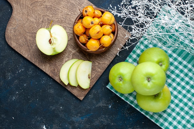 Top view of fresh green apples with sweet cherries on dark desk, fruit fresh mellow ripe