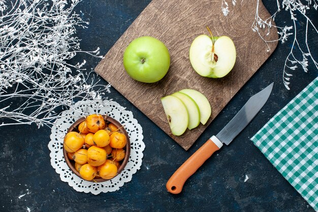 Top view of fresh green apples with sweet mellow cherries on blue-dark desk, fruit fresh mellow food vitamine