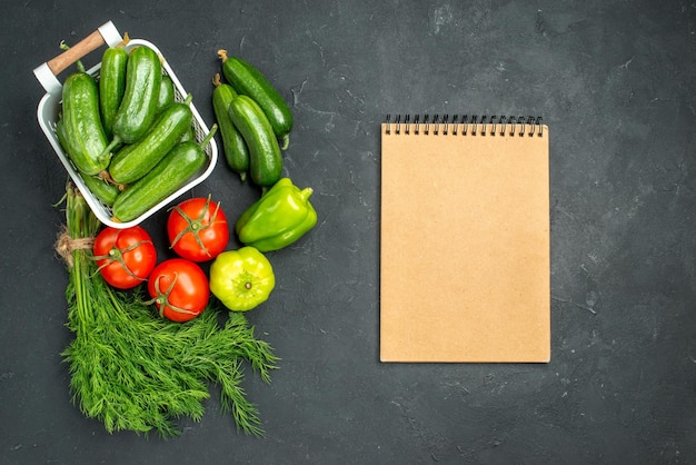 Free photo top view fresh green cucumbers with greens and vegetables on dark background