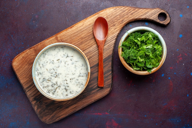 Free photo top view fresh greens inside round bowl with dovga on dark table, green fresh food vegetable