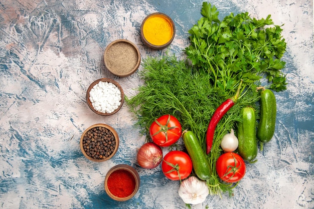 Top view fresh greens with vegetables and seasonings on a light background