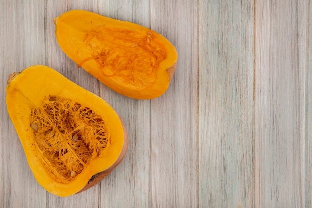 Top view of fresh half pumpkin isolated on a grey wooden wall with copy space