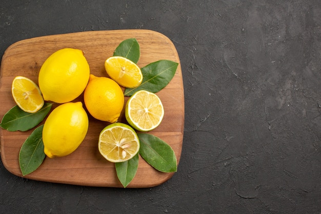 Free photo top view fresh lemons sour fruits on a dark-grey table citrus fruit lime