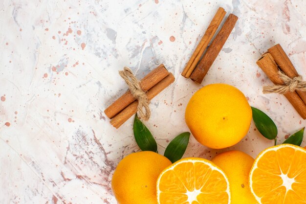 Top view fresh mandarines cut mandarines cinnamon sticks on bright isolated surface free place