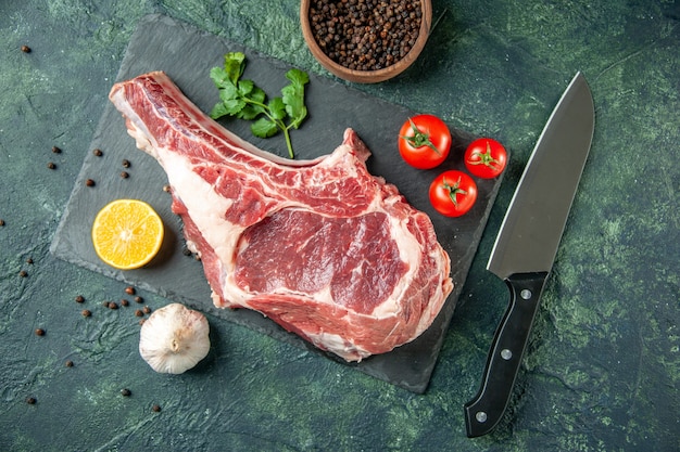 Top view fresh meat slice with red tomatoes on dark-blue background kitchen animal cow butcher meat chicken color