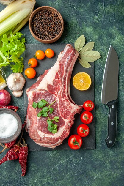 Top view fresh meat slice with tomatoes on dark-blue background food meat kitchen animal chicken color cow butcher